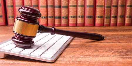 Legal Law and Justice concept - Open law book with a wooden judges gavel on table in a courtroom or law enforcement office. Copy space for text.の写真素材