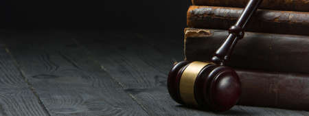 Legal Law and Justice concept - Open law book with a wooden judges gavel on table in a courtroom or law enforcement office. Copy space for text.の写真素材