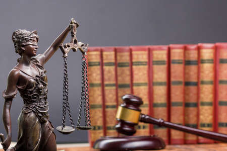 Legal Law and Justice concept - Open law book with a wooden judges gavel on table in a courtroom or law enforcement office. Copy space for textの写真素材