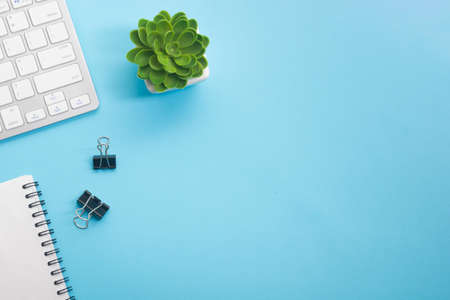 Blue desk office with laptop, smartphone and other work supplies with cup of coffee. Top view with copy space for input the text. Designer workspace on desk table essential elements on flat lay.の写真素材