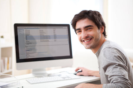 View of a Young smiling man in front of computerの写真素材
