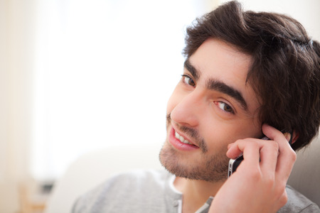 View of a Young man having a call in a sofaの写真素材