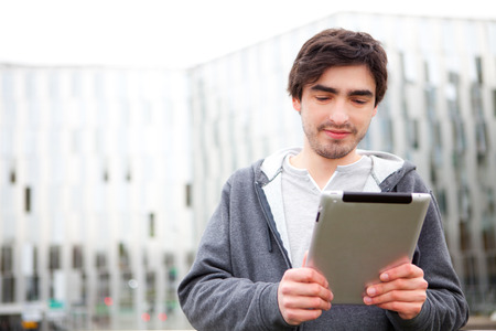View of a young relaxed men using tablet in the streetの写真素材