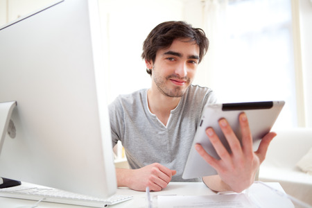 View of a  young relaxed men at the office using tabletの写真素材