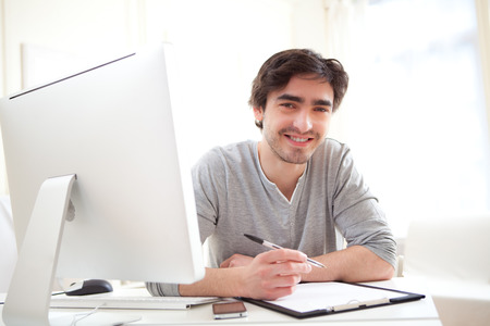 View of a young relaxed men writting at the office の写真素材