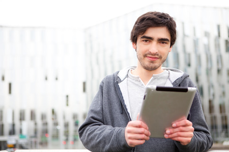 View of a young relaxed men using tablet in the streetの写真素材