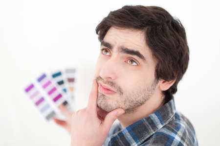 View of a Attractive young man choosing color of his flatの写真素材