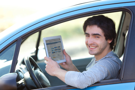 View of a Young man using a tablet in his car