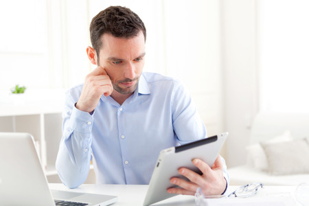 View of a Young business man working at home on his tabletの写真素材