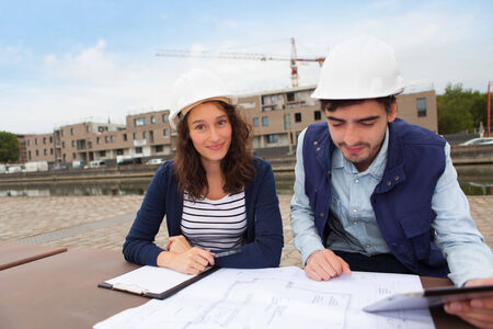 Architect woman and construction site supervisor watching plansの写真素材