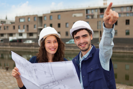 Architect woman and construction site supervisor watching plans