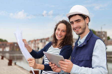 Architect woman and construction site supervisor watching plansの写真素材