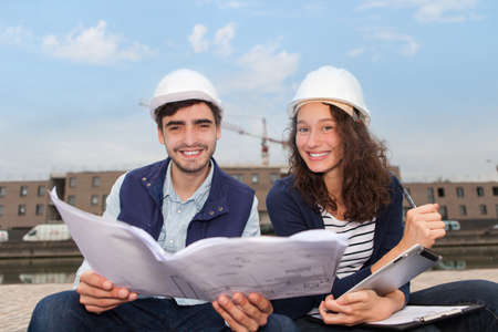 Architect woman and construction site supervisor watching plansの写真素材