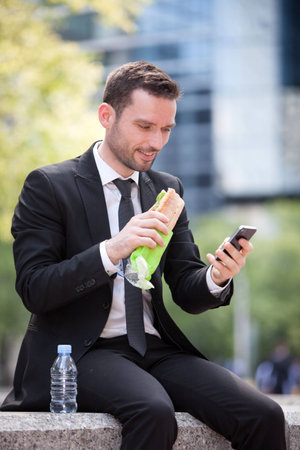 View of a Businessman eating sandwich for lunch breakの写真素材