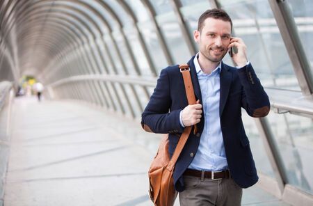 View of a Young attractive man having a call in a airport hallの写真素材