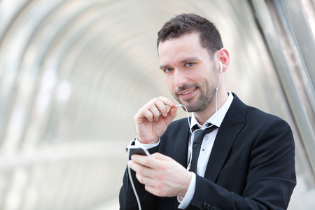 View of an attractive businessman using handsfree setの写真素材