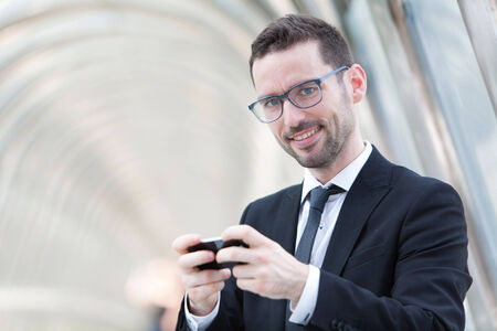 View of an attractive Businessman sending a text during a breakの写真素材