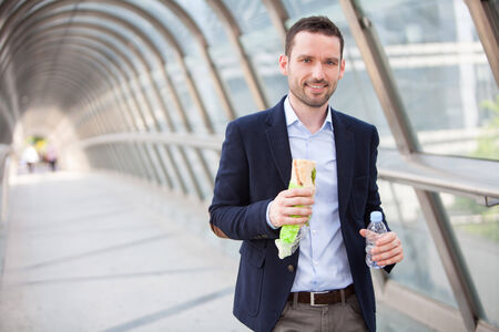 View of a Young attractive man eating fast his lunchの写真素材