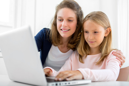 View of a Attractive woman and little sister using laptop