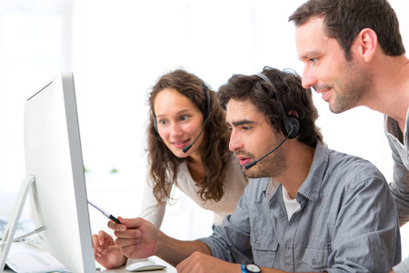 View of a Group of people working around a computerの写真素材