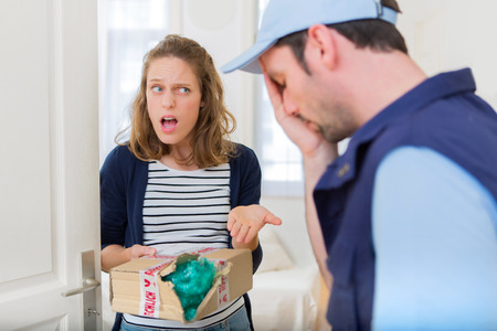 View of a Young attractive woman angry against delivery manの写真素材