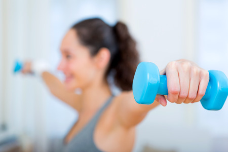 View of a Young attractive girl doing exercise at home with dumbellの写真素材