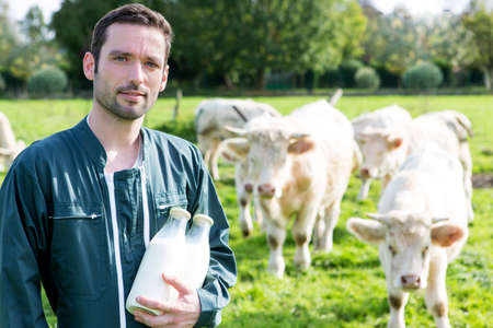 View of a Young attratcive farmer with bottle of milkの写真素材