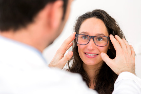 View of a Young attractive woman trying glasses with opticianの写真素材