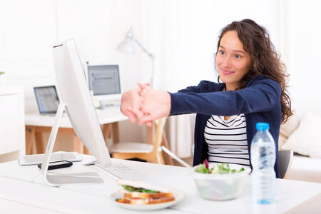 View of a Young attractive woman stretching during a meal breakの写真素材