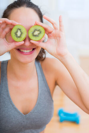View of an Attractive sportive woman eating kiwi after sportの写真素材