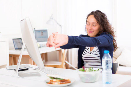 View of a Young attractive woman stretching during a meal breakの写真素材