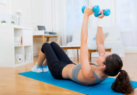 view of a Young attractive girl doing exercise at homeの写真素材