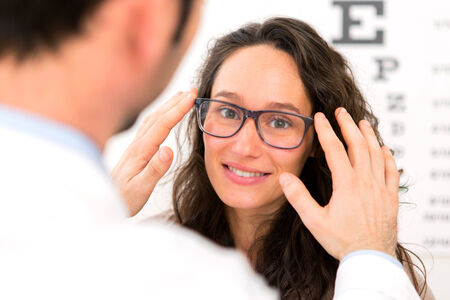 View of a Young attractive woman trying glasses with opticianの写真素材