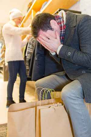 View of a Young casual man waiting while his wife's shoppingの写真素材