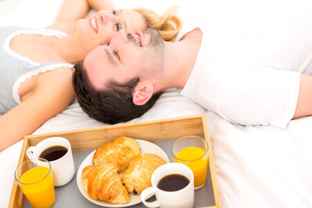 View of a Portrait of a couple having breakfast in bedの写真素材