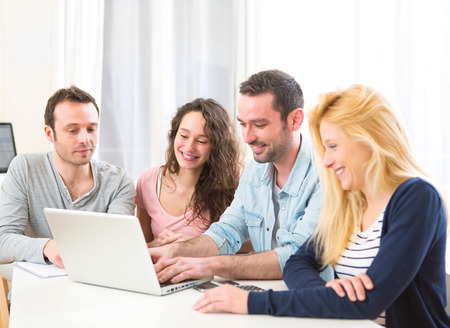 View of a Group of 4 young attractive people working on a laptopの写真素材