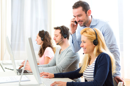 View of a Manager training a young attractive people on computerの写真素材