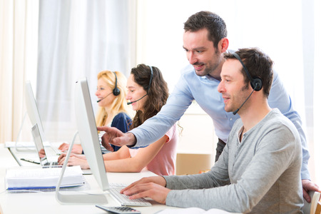 View of a Manager training a young attractive people on computer