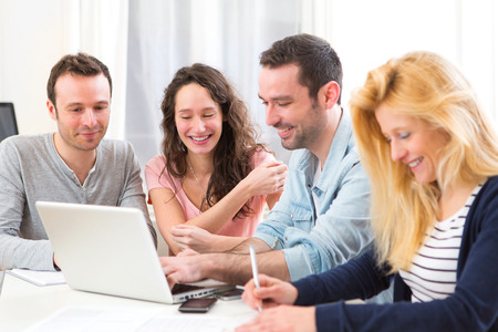 View of a Group of 4 young attractive people working on a laptopの写真素材