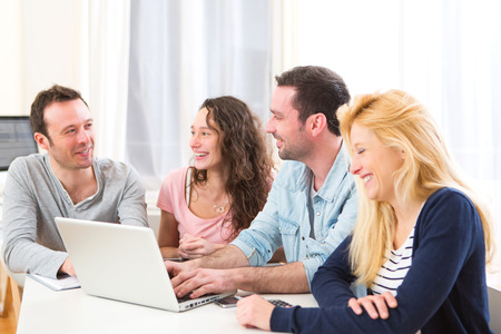 View of a Group of 4 young attractive people working on a laptopの写真素材