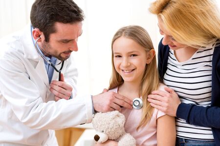 View of a Doctor listening heart beatment of little girlの写真素材