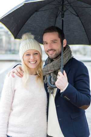 View of a Portrait of a young couple on holidays under the rainの写真素材