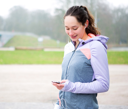 View of a Young attractive woman adjust her music player before runningの写真素材