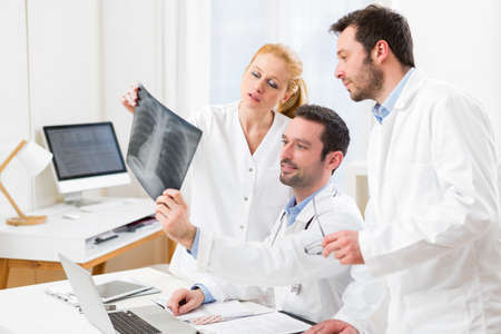 View of a Medical team analysing together a x ray at the hospitalの写真素材