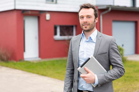 View of a young real estate agent in front of a houseの写真素材
