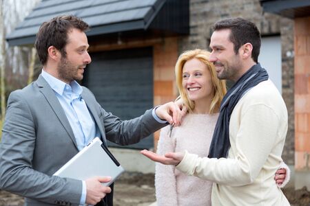 View of a Real estate agent delivers keys to young atractive coupleの写真素材