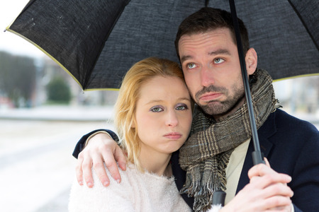 View of a Portrait of a young couple on holidays under the rainの写真素材