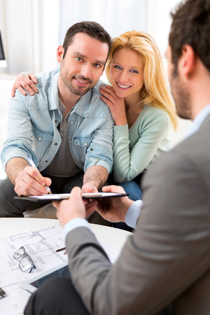 View of Young attractive couple signing contract with real estate agentの写真素材