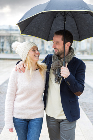 View of a Portrait of a young couple on holidays under the rainの写真素材
