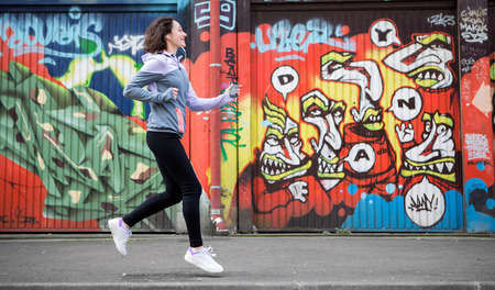 View of a Young attractive woman running downtownの写真素材